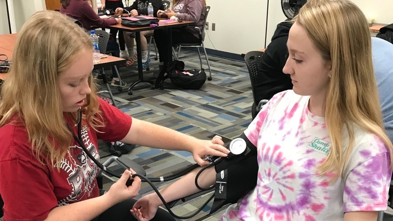Healthcare Foundations students learning how to do blood pressure checks.